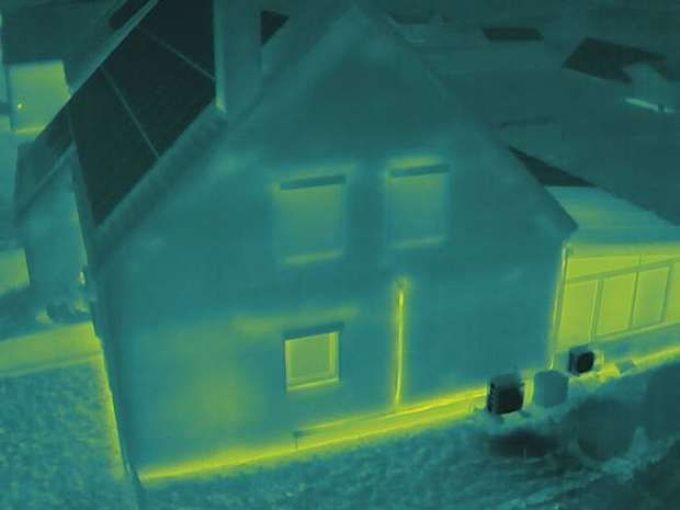 Vue thermique d'une façade : châssis, sortie de pompe à chaleur et jonction avec le sol plus chauds