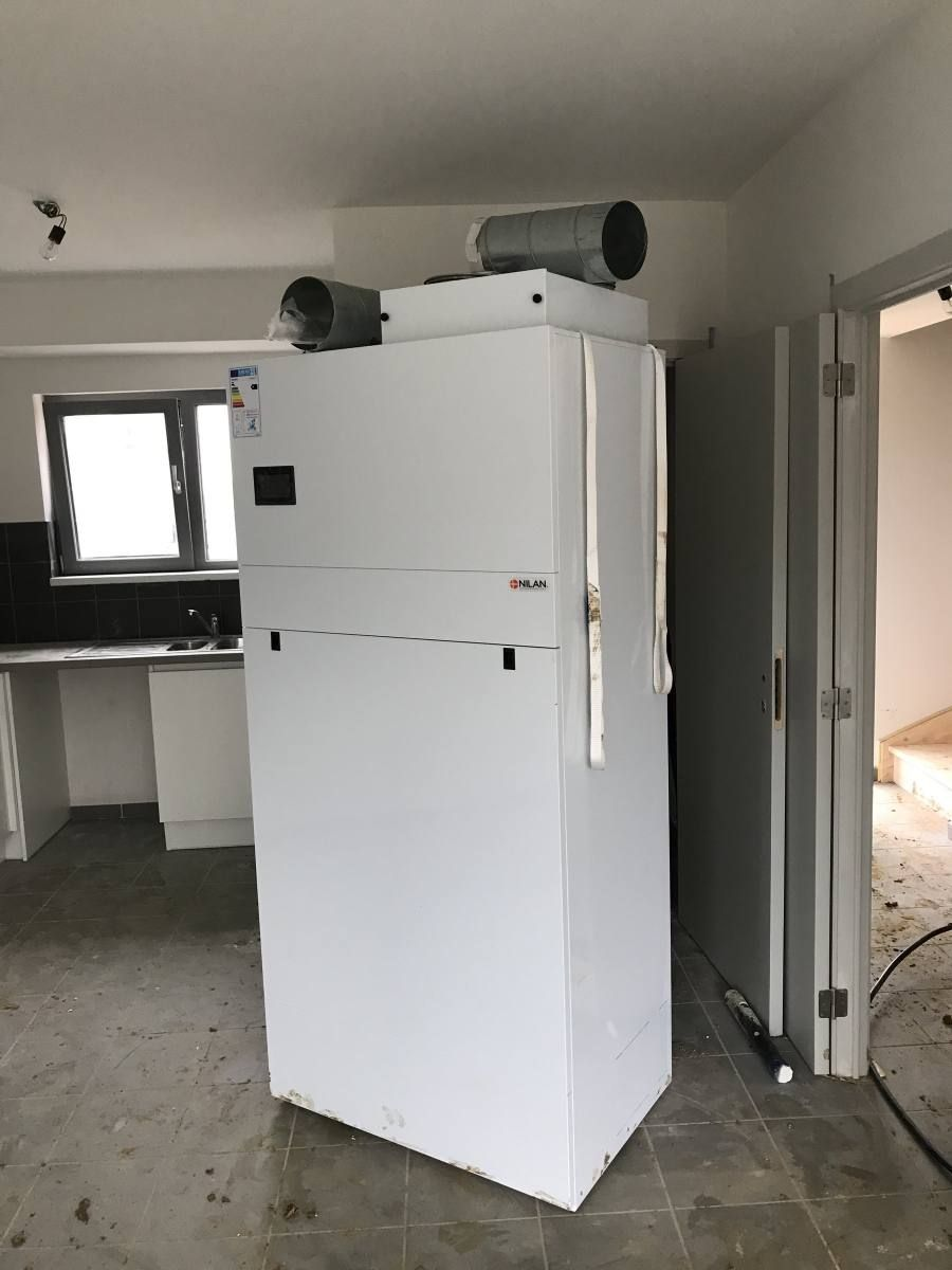 Compact P posé dans un logement fini, cuisine derrière.
